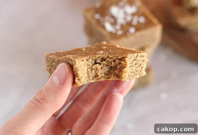 Hand holding a healthy almond butter bar.