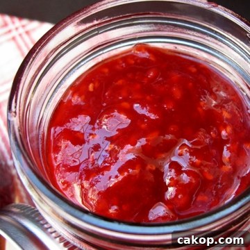 8 ounce jar of raspberry apricot jam with the lid off.