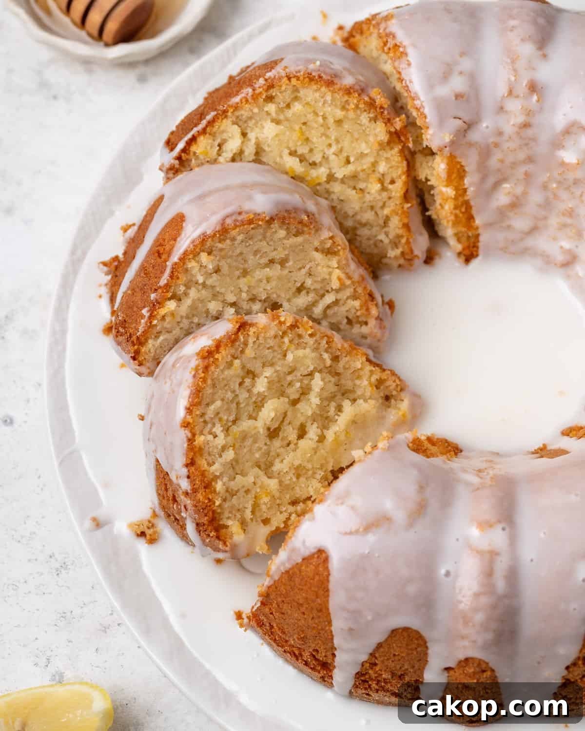 A sliced lemon pound cake sitting on a white plate.