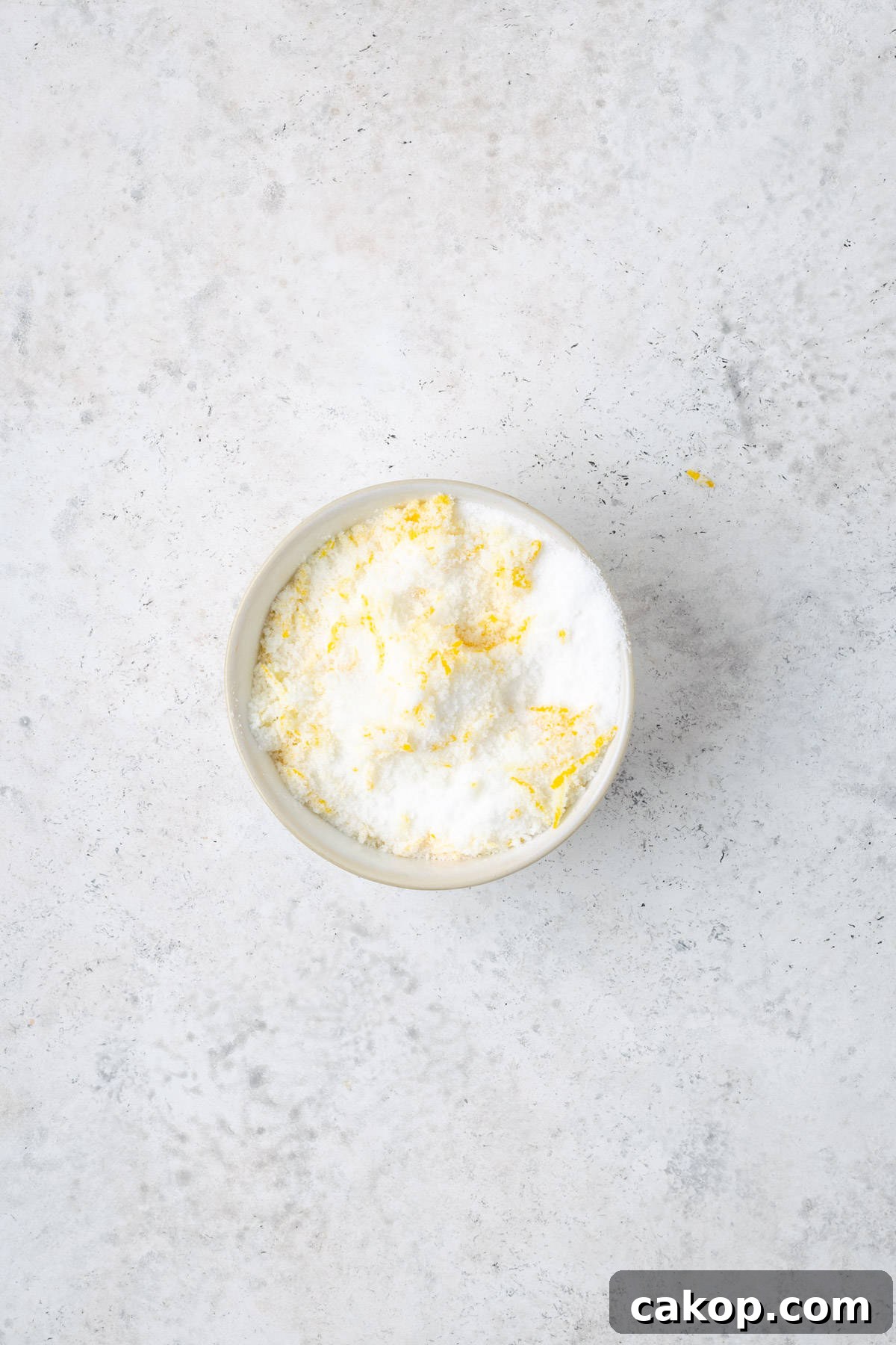 Lemon zest mixed with white sugar in a small bowl.
