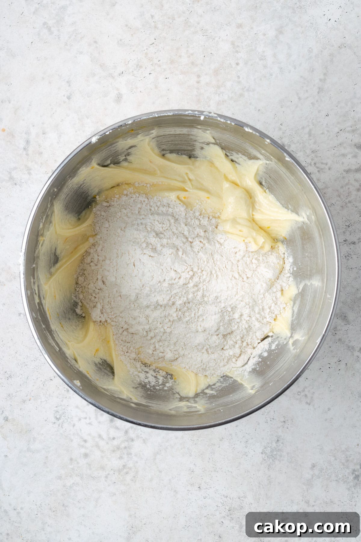 Dry ingredients being added to the partially mixed cake batter.