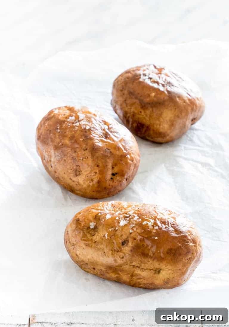 Crispy Air Fryer Baked Potatoes Recipe for Perfectly Fluffy Centers 3 three potatoes on a countertop seasoned and ready to be put in the air fryer to make air fryer baked potatoes