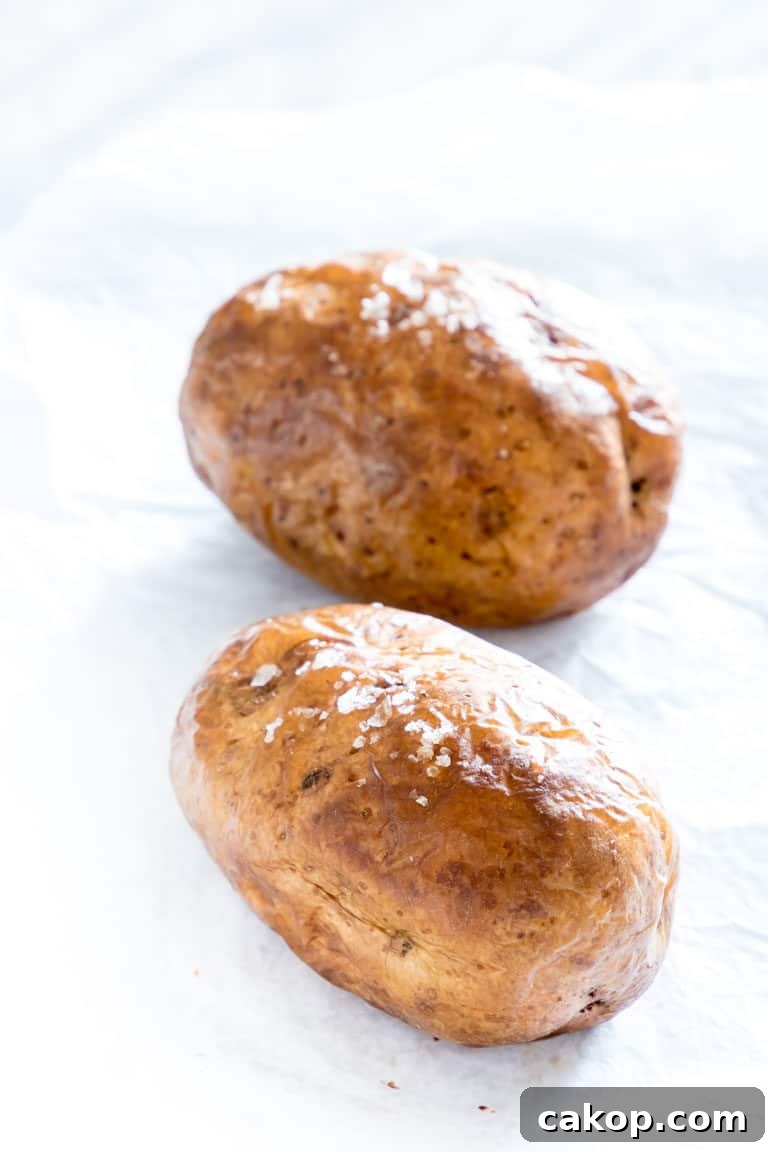 Crispy Air Fryer Baked Potatoes Recipe for Perfectly Fluffy Centers 6 two air fryer baked potatoes on a counter and ready to serve