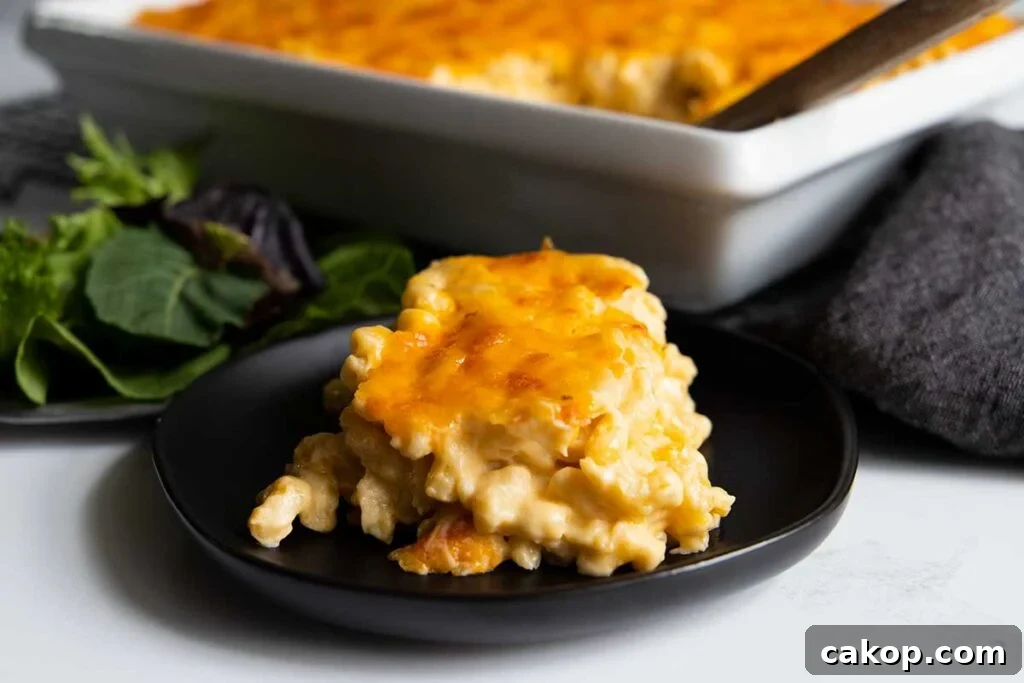 A serving of macaroni and cheese on a black plate.
