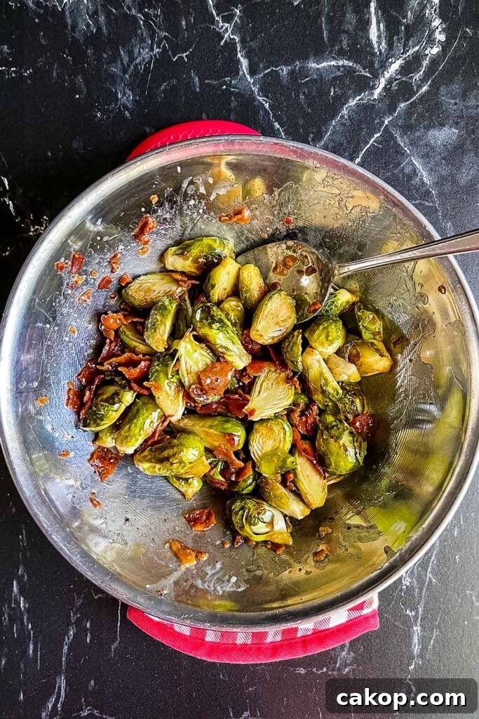 Roasted Brussels Sprouts with Bacon and Honey-Butter Glaze 9 Roasted brussels sprouts with honey butter and bacon in a stainless steel bowl.