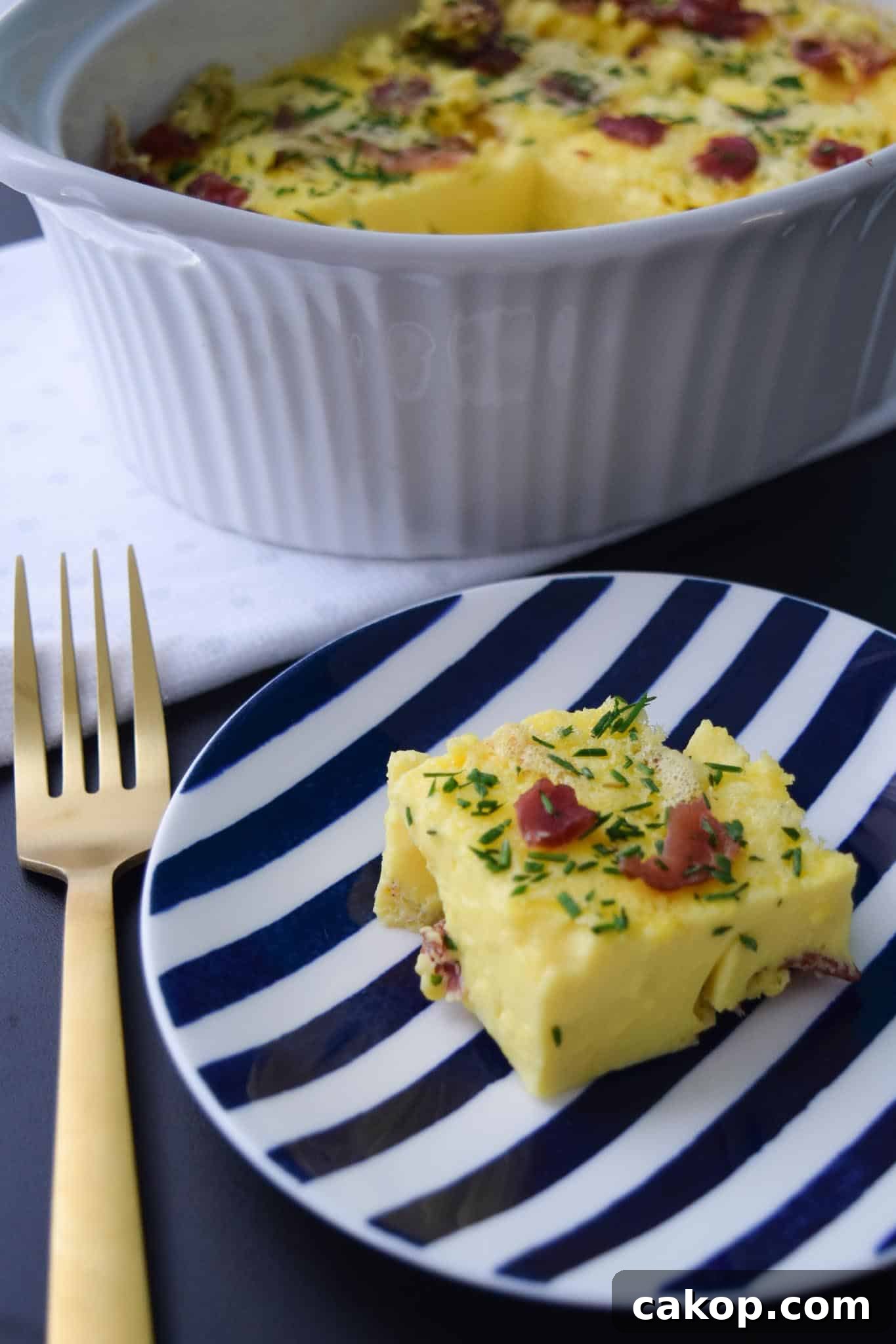 Bacon and Gruyere Breakfast Casserole piece on blue and white plate ready to be served