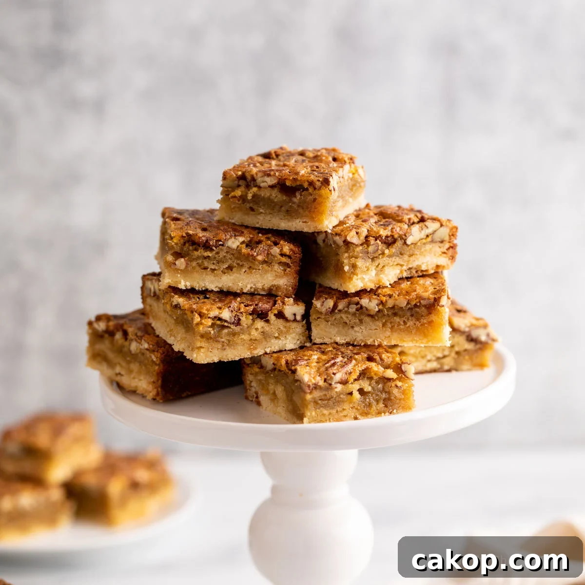 A cake stand filled with pecan bar squares.