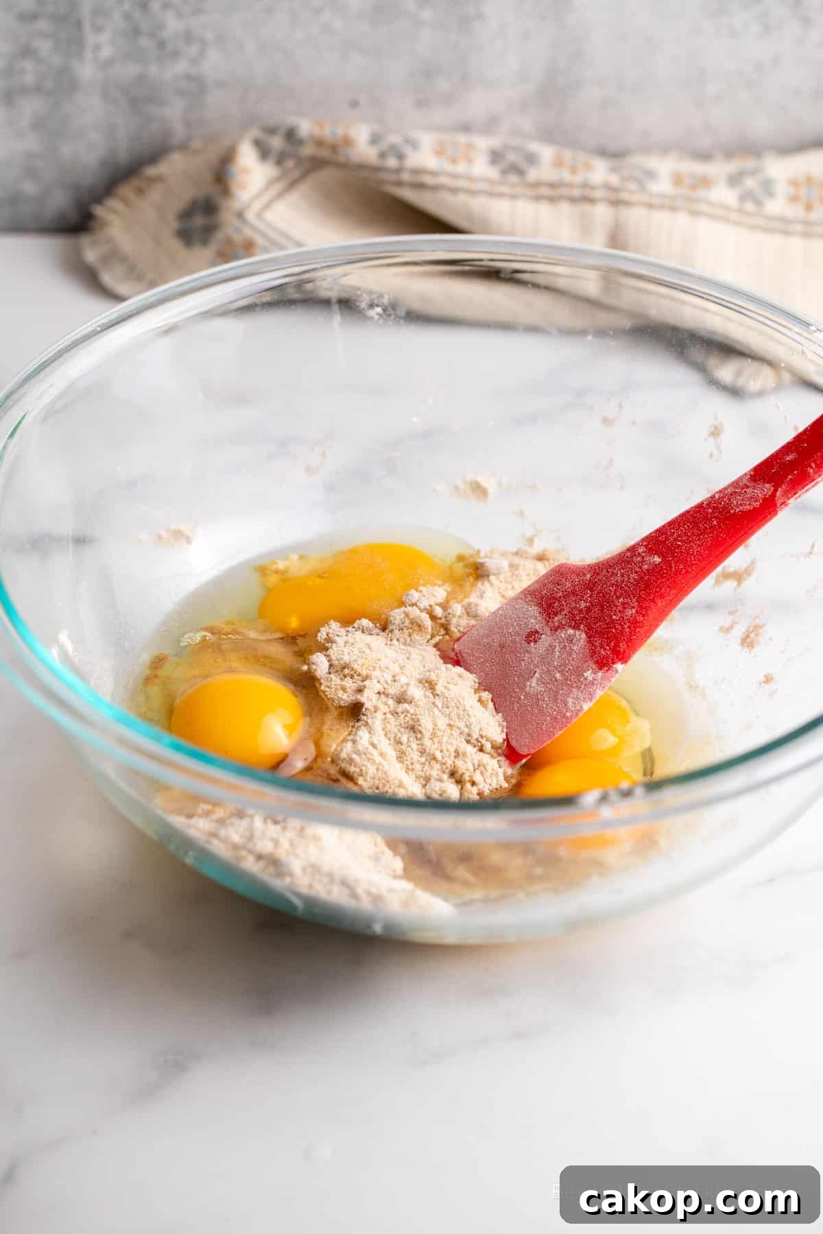Mixing eggs with flour in a bowl.