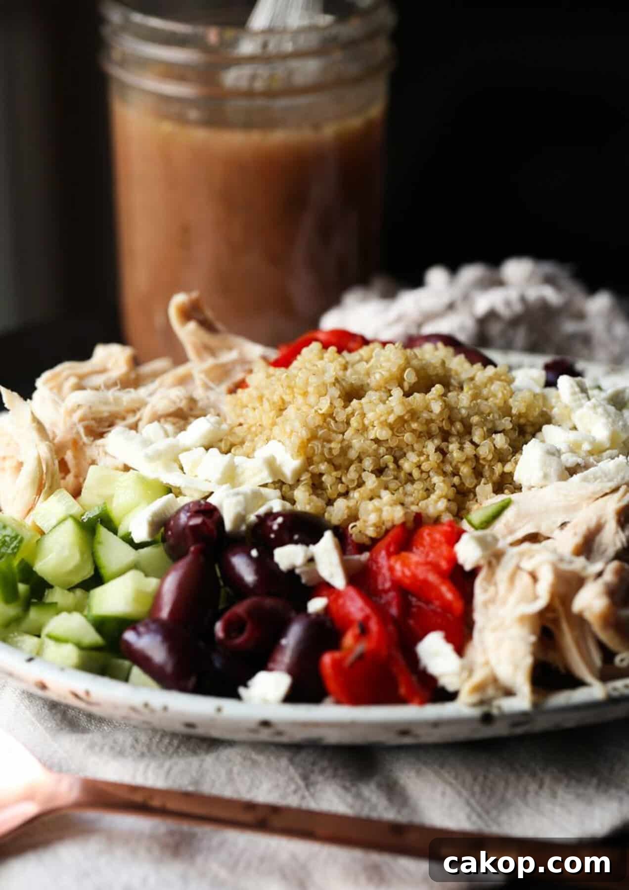 Greek Quinoa Salad displayed on a plate with a dressing 