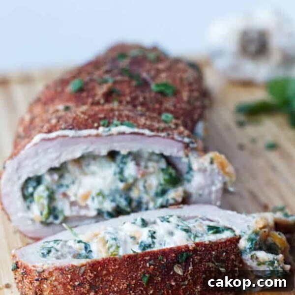 Double-Smoked Ham Recipe: How to Smoke Perfect Ham at Home 15 sliced stuffed pork tenderloin with cajun rub and twine holding it together, cheese stuffing, cilantro and garlic cloves sitting on wood
