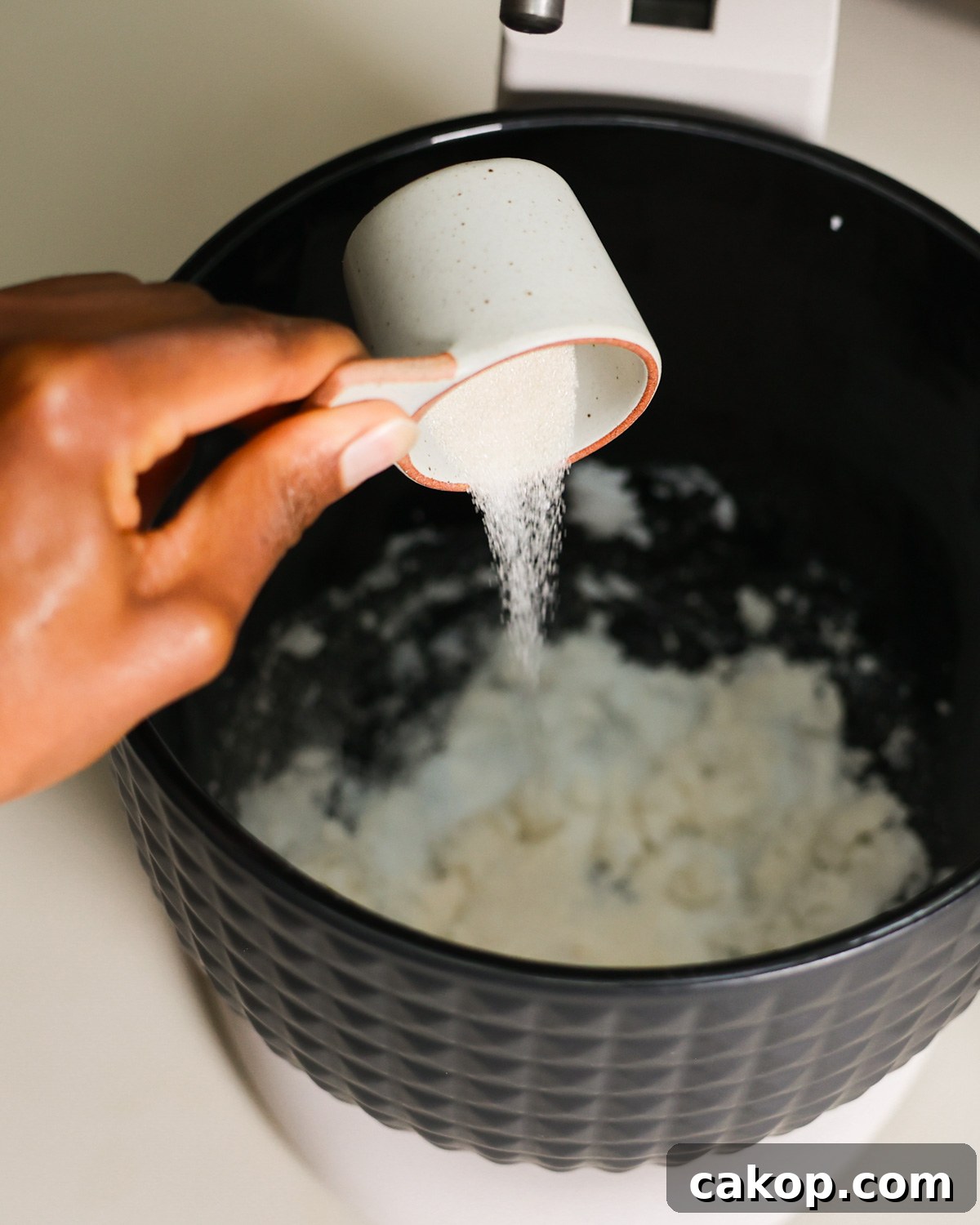 adding sugar to mixer