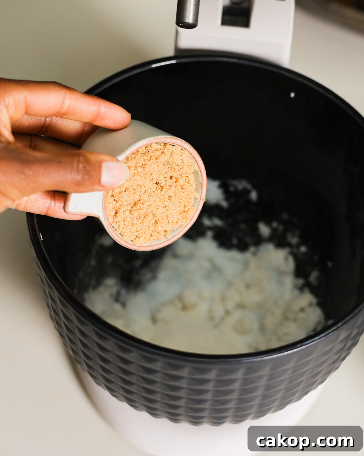 adding brown sugar to mixer