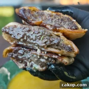 A close-up of the Cowboy Butter Arayes in the hands of Derek Wolf, juicy and tasty looking.