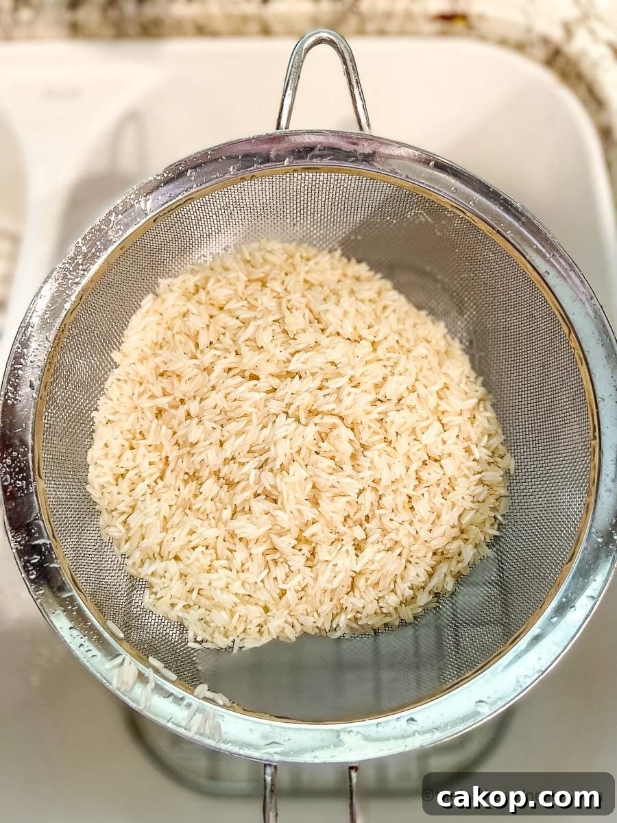 Rinsed rice in a mesh colander.