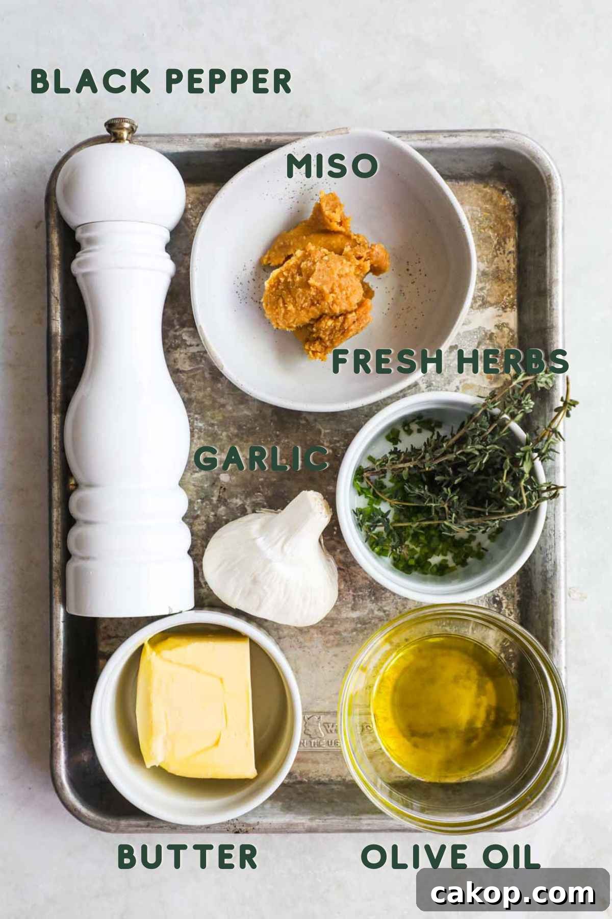 Miso Garlic Butter Spread Recipe for Savory Dishes 3 Ingredients to make miso garlic butter paste, butter, fresh herbs, garlic, olive oil, white miso, and black pepper.