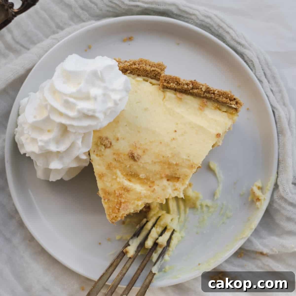 slice of pudding pie on a plate with whip cream and a fork
