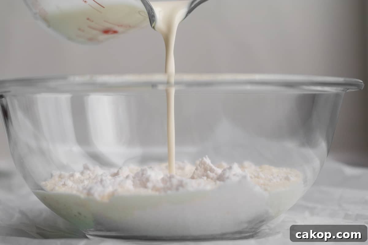 cream being added to pudding mix in glass bowl.