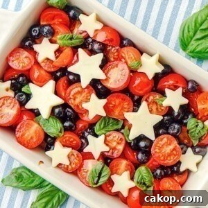 Blueberries, tomatoes, and mozzarella cheese shaped into stars, in a rectangle baking dish.