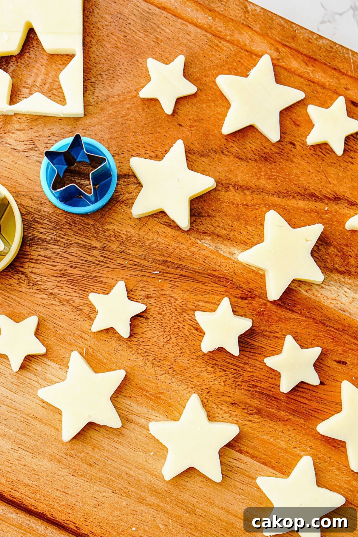 Berry Caprese Salad with Fresh Mozzarella and Balsamic 6 Mozzarella cheese cut into star shapes on a wooden cutting board.