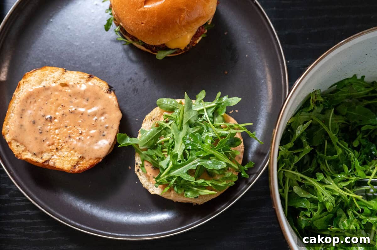 Reverse-Sear Smoked and Grilled Burgers for Juicy Results 13 dressed arugula on bun.