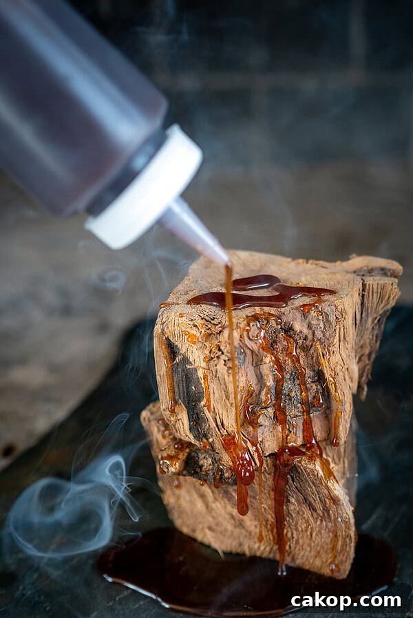 Reverse-Sear Smoked and Grilled Burgers for Juicy Results 17 Drizzling hot honey on wood with smoke in background.
