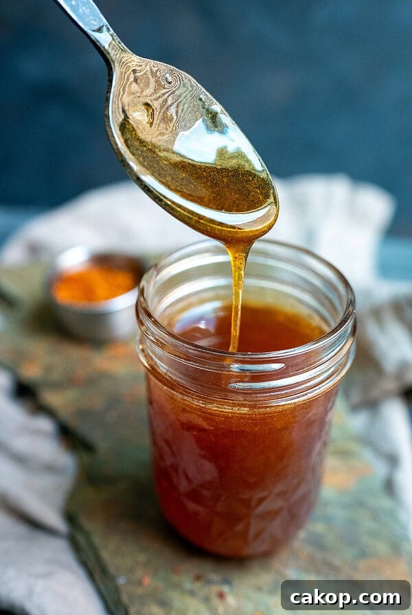 Reverse-Sear Smoked and Grilled Burgers for Juicy Results 18 Spoon drizzling gochugaru hot honey.