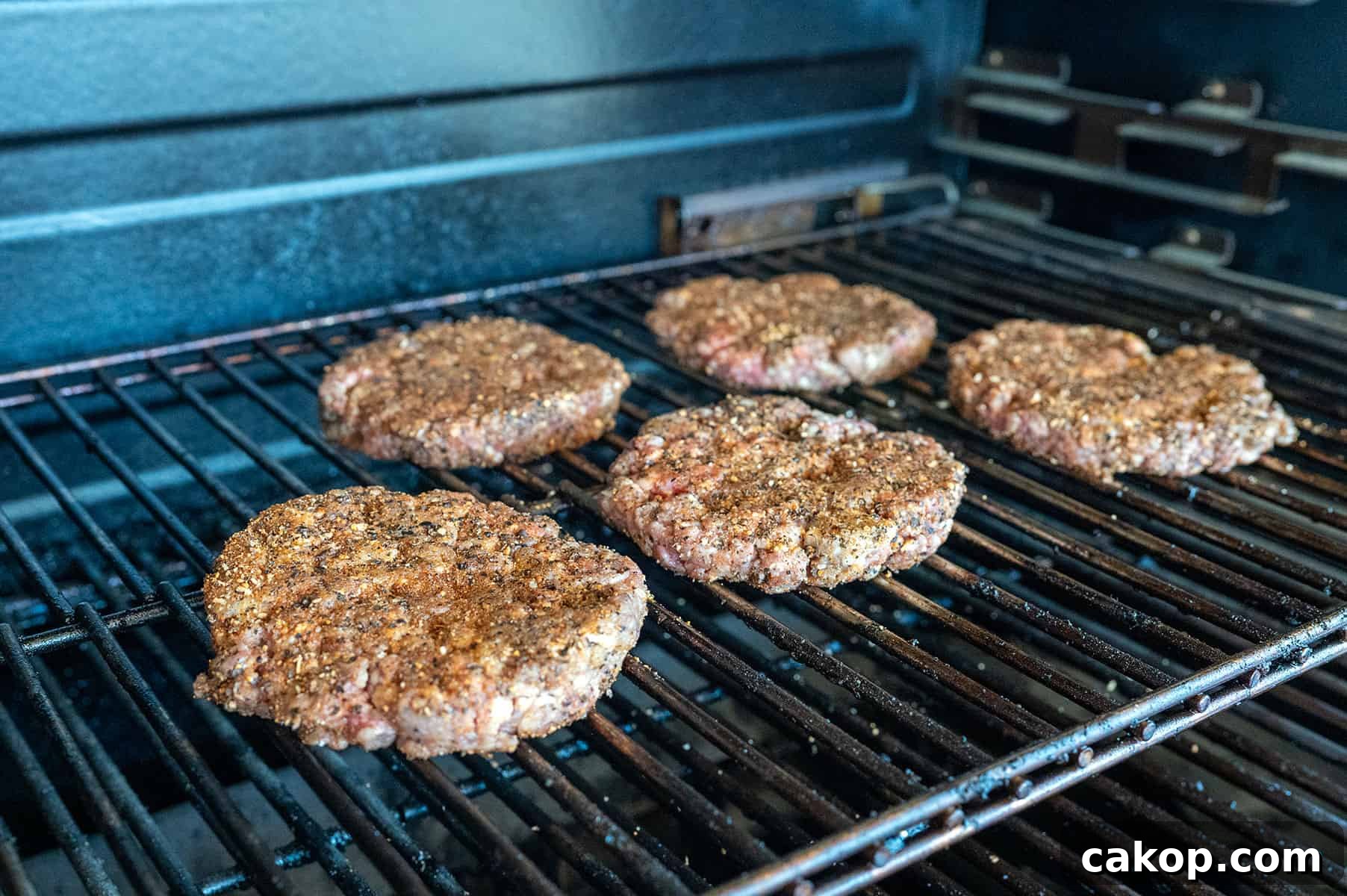 Reverse-Sear Smoked and Grilled Burgers for Juicy Results 7 raw patties on grill.