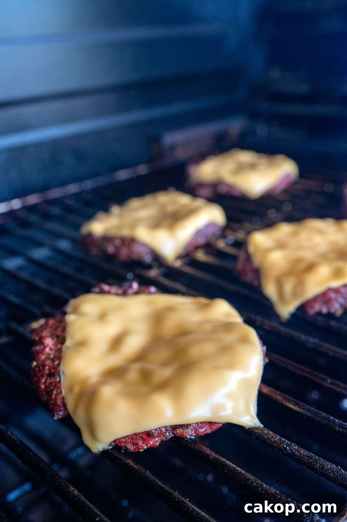 Reverse-Sear Smoked and Grilled Burgers for Juicy Results 8 cheese melting on burger patty.