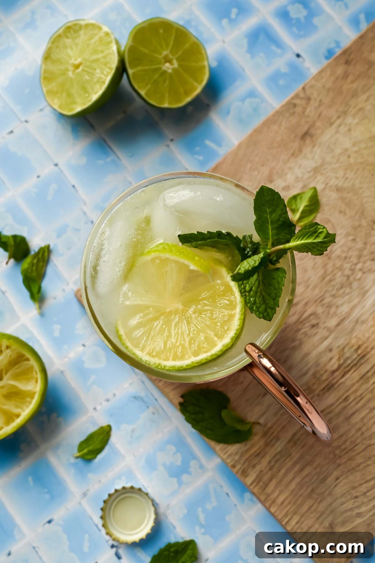 a copper mug filled with tequila mule, lime wedges, and mint sprigs.