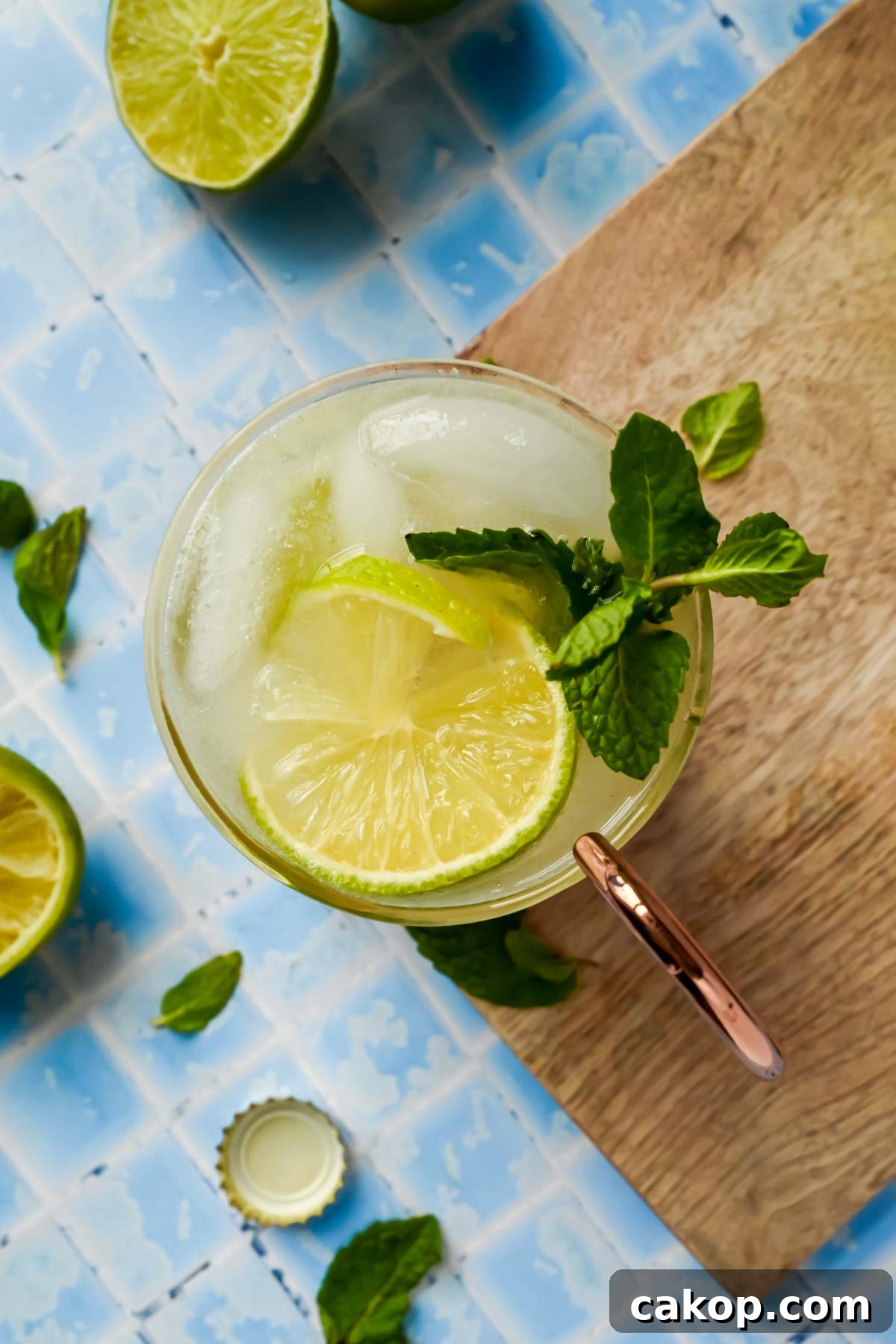a copper mug filled with tequila mule, lime wedges, and mint sprigs.