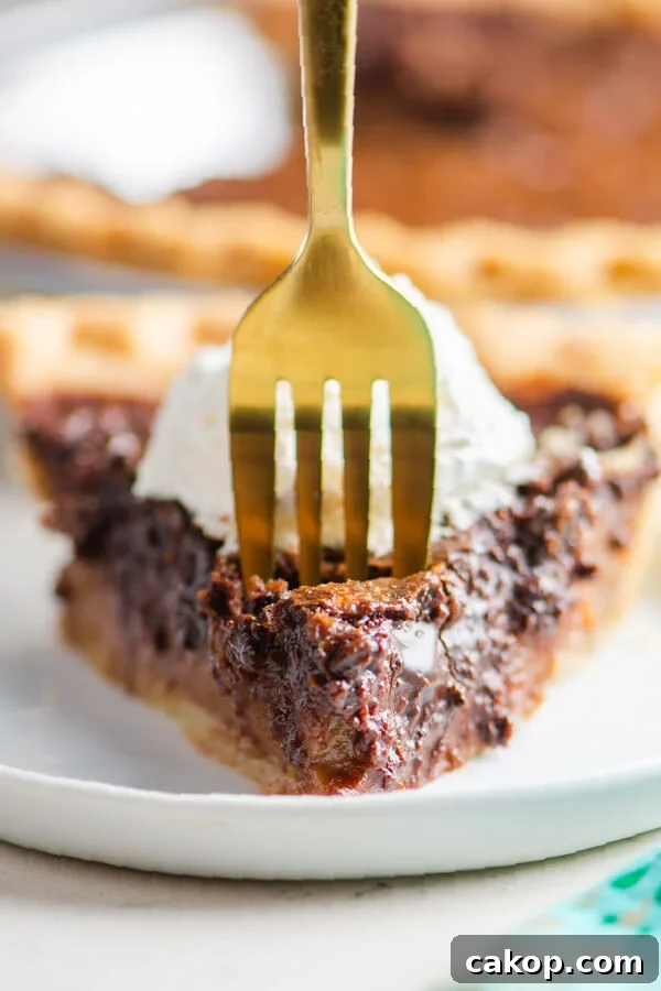 a fork taking off a bite of pie from the slice