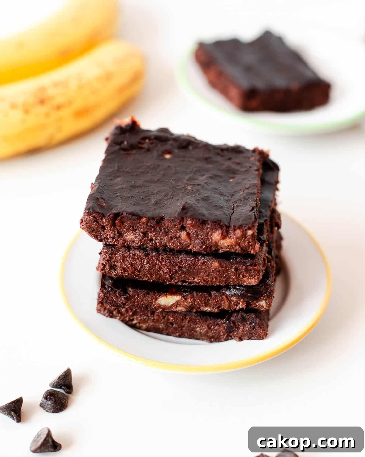 Side view of stacked flourless 3 ingredient banana brownies highlighting thick, chewy texture.