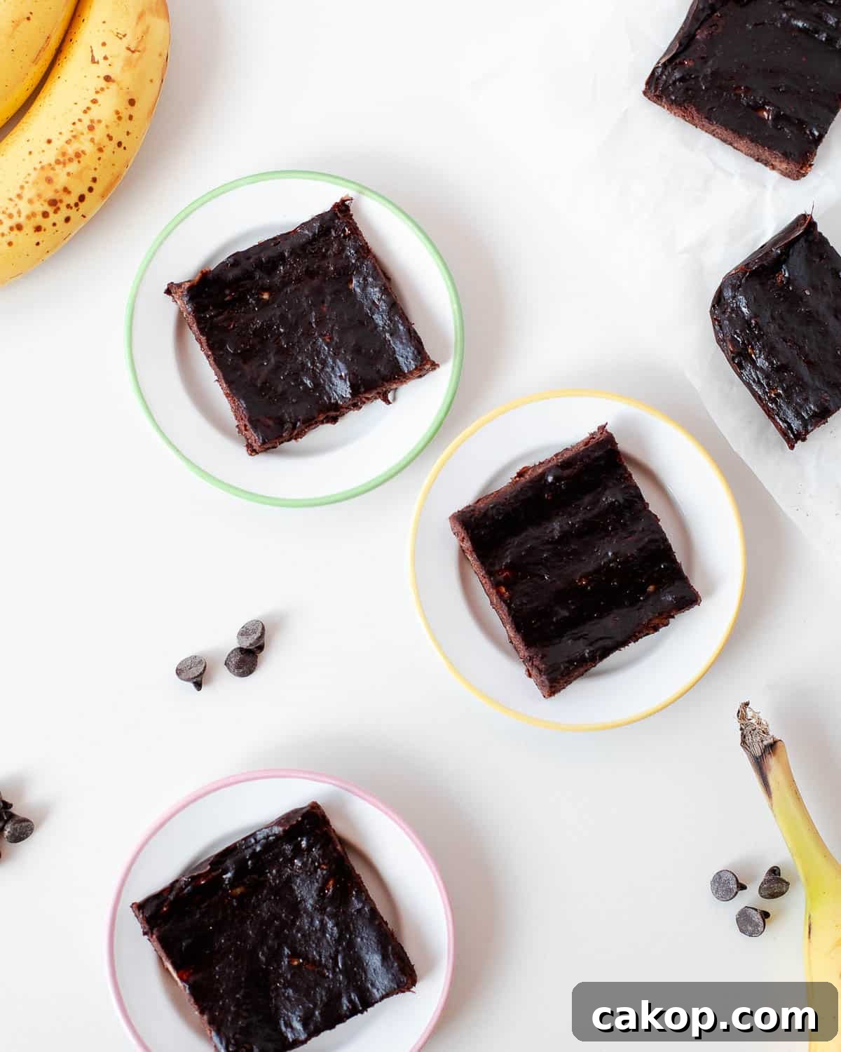 3 ingredient banana brownies served on small plates with chocolate chips and ripe bananas.