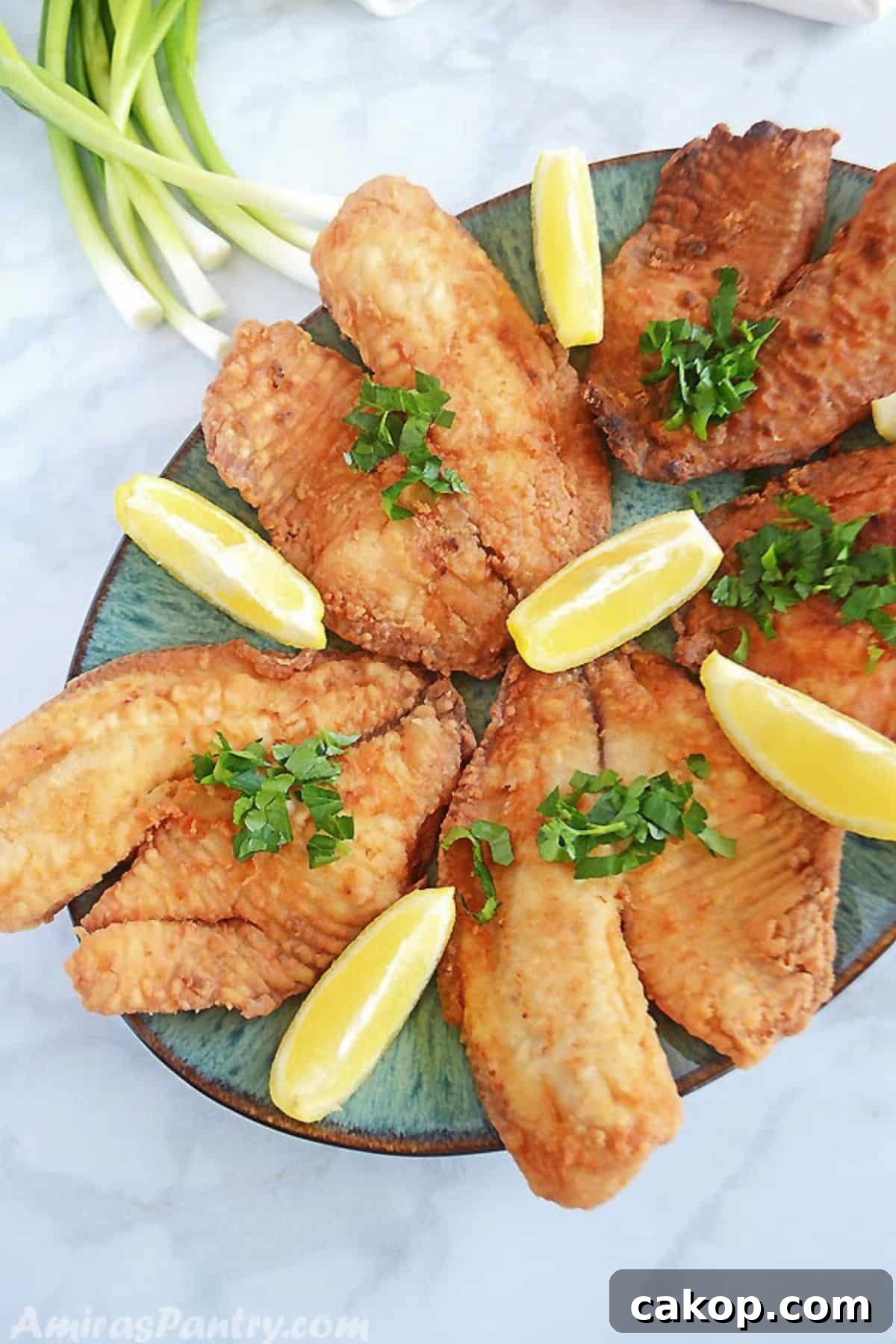 Top Side Dishes to Serve with Fried Fish 2 Fried fish garnished with parsley and lemon wedges.