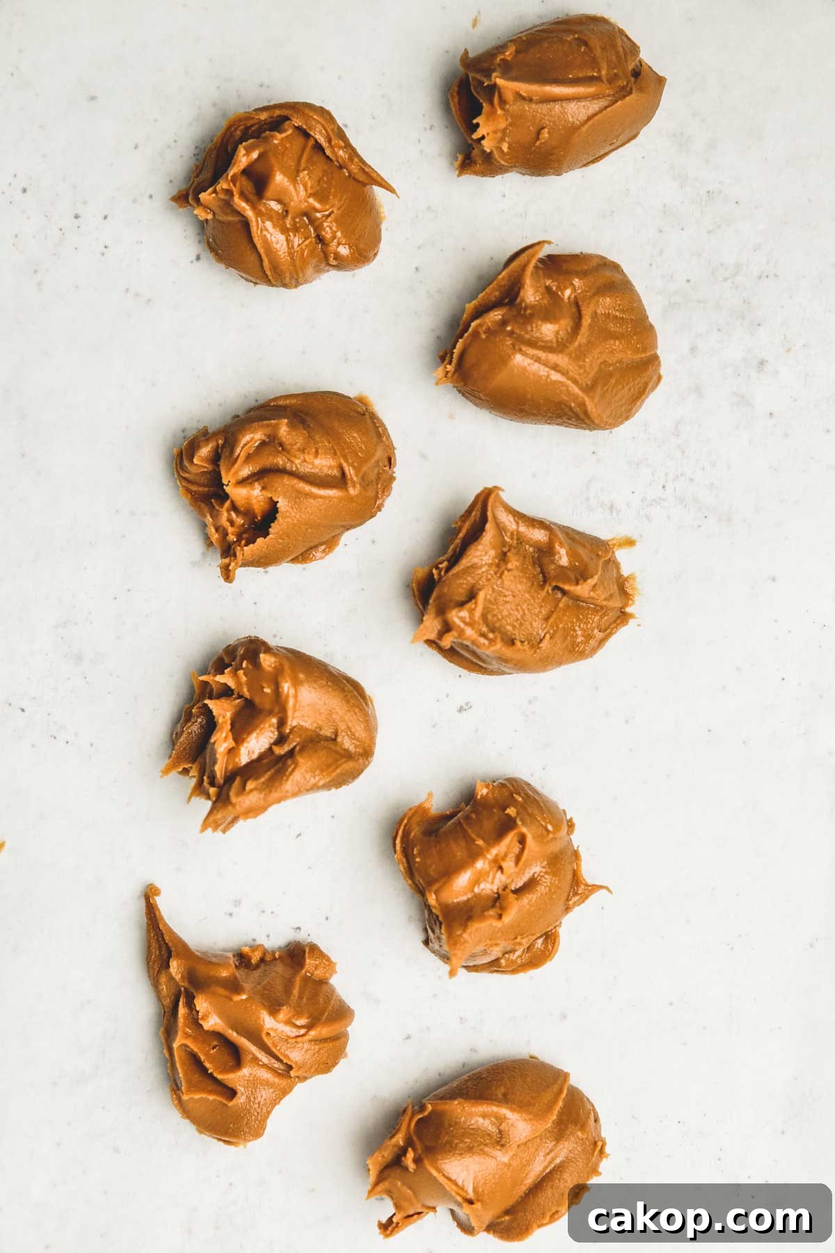 Biscoff Cookie Butter Cookies Recipe — Crunchy Spiced Biscuits 4 frozen scoops of Biscoff spread on parchment paper