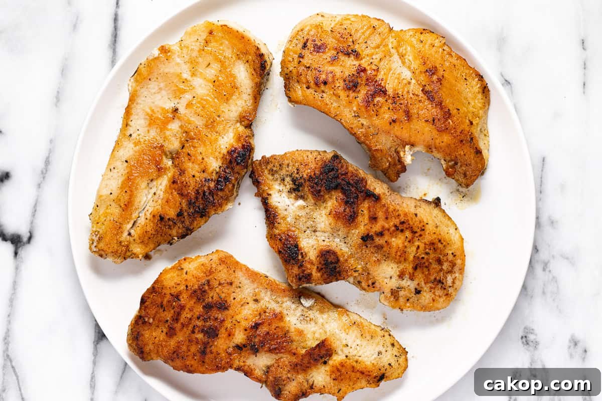 Sauteed chicken cutlets on a white plate.