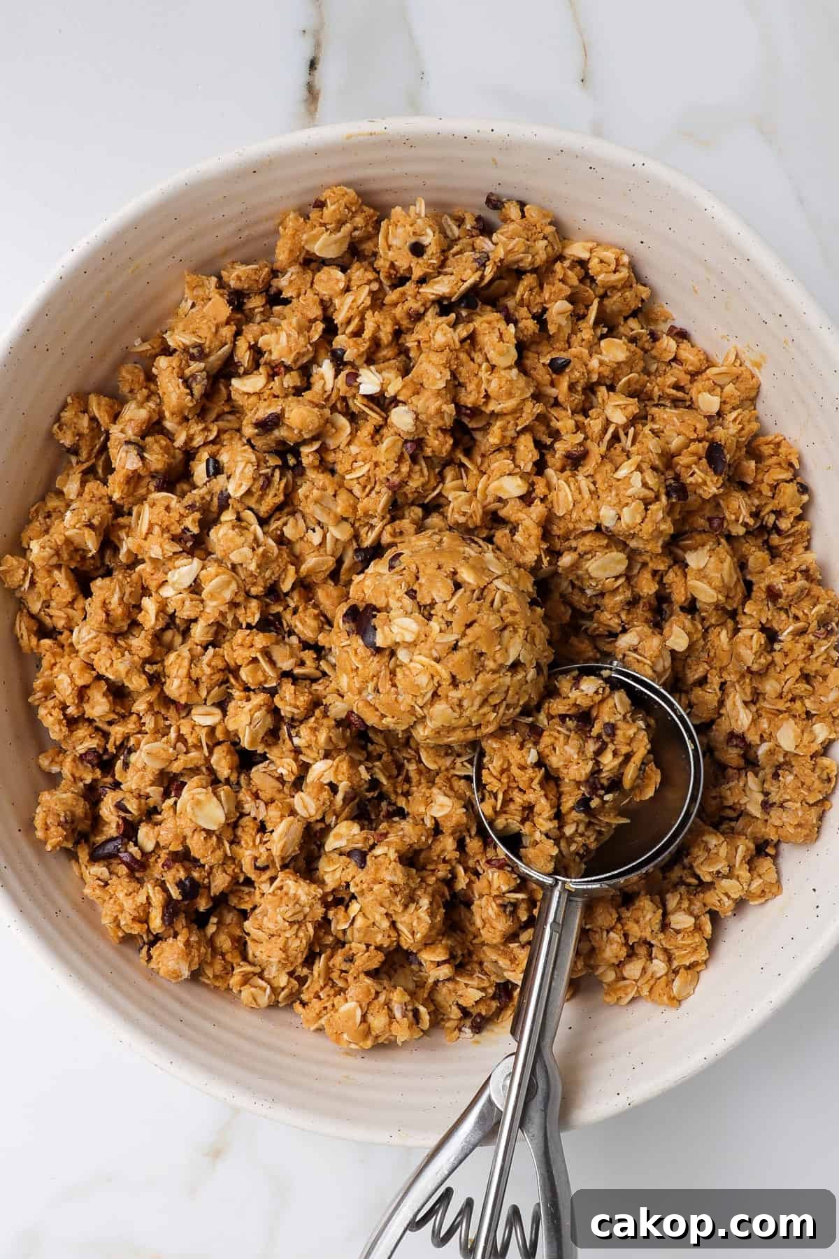 Mixture in a bowl with a cookie scoop.