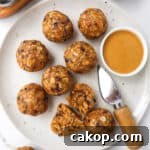 Bliss balls on a plate with a knife and dish of peanut butter.