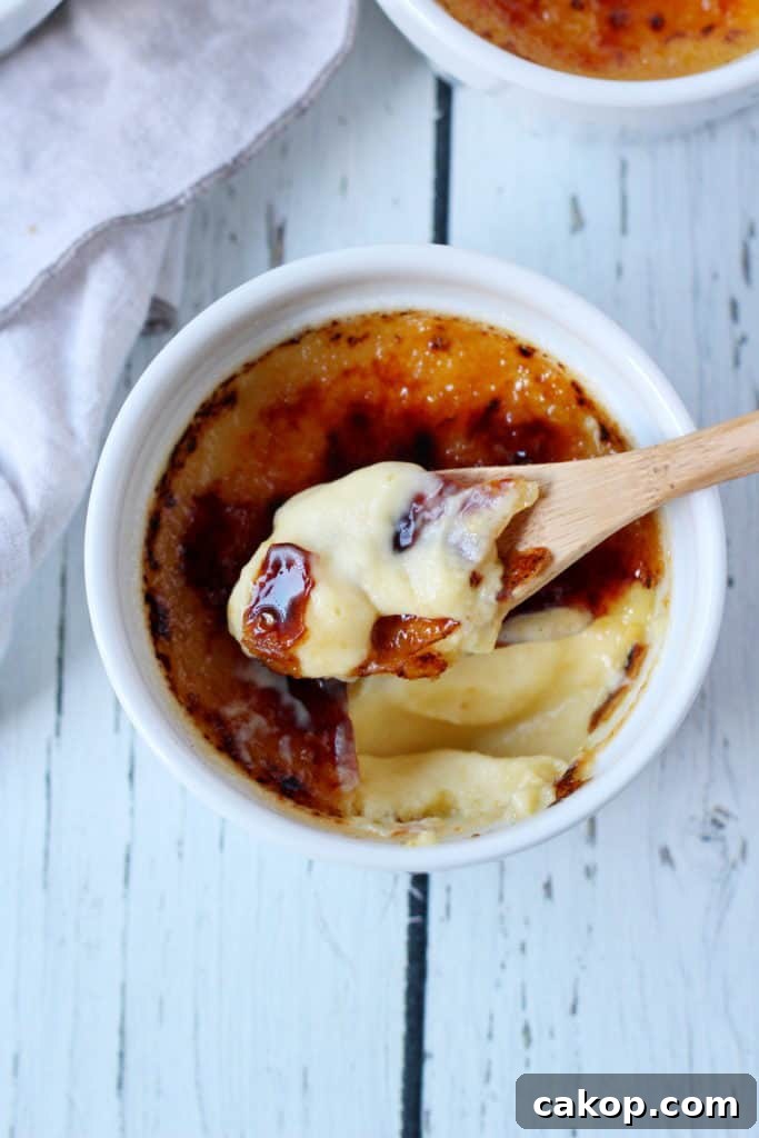 creme brule in ramekin with spoon taking first bite
