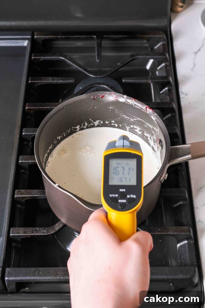 Homemade Strawberry Ice Cream Recipe with Fresh Berries 7 A thermometer reads 167°F over a pot of cooked custard.