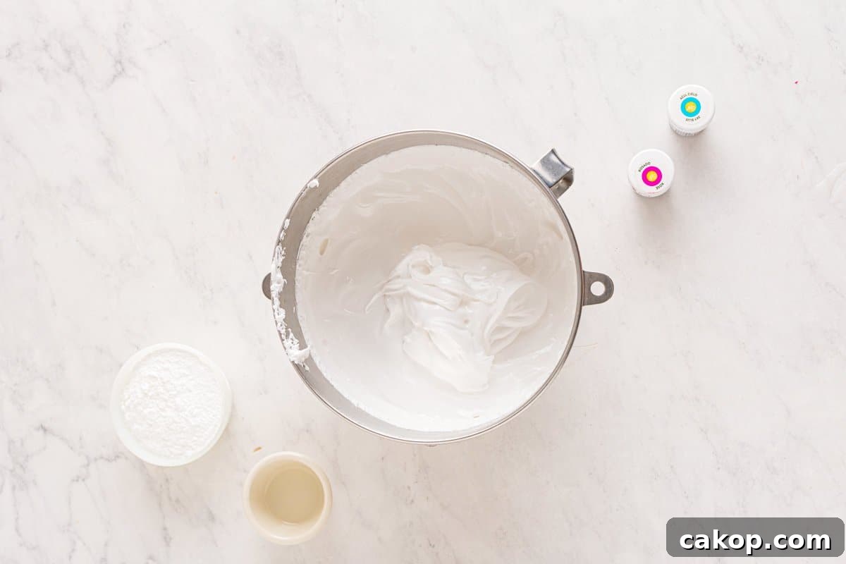 Cotton Candy Marshmallows: Fluffy Homemade Treats to Try 7 fluffy whipped marshmallow mixture in a stainless mixing bowl.