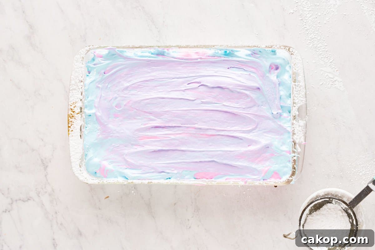 Cotton Candy Marshmallows: Fluffy Homemade Treats to Try 9 swirled cotton candy marshmallow mixture in a white rectangular pan.