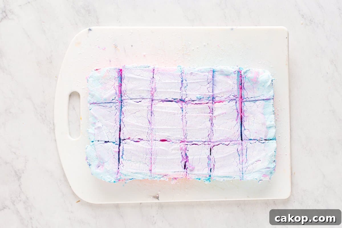 Cotton Candy Marshmallows: Fluffy Homemade Treats to Try 10 set cotton candy marshmallows cut into a 6 by 3 grid on a white cutting board.