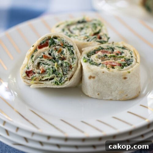 three Spinach Dip Roll-Ups on a plate.