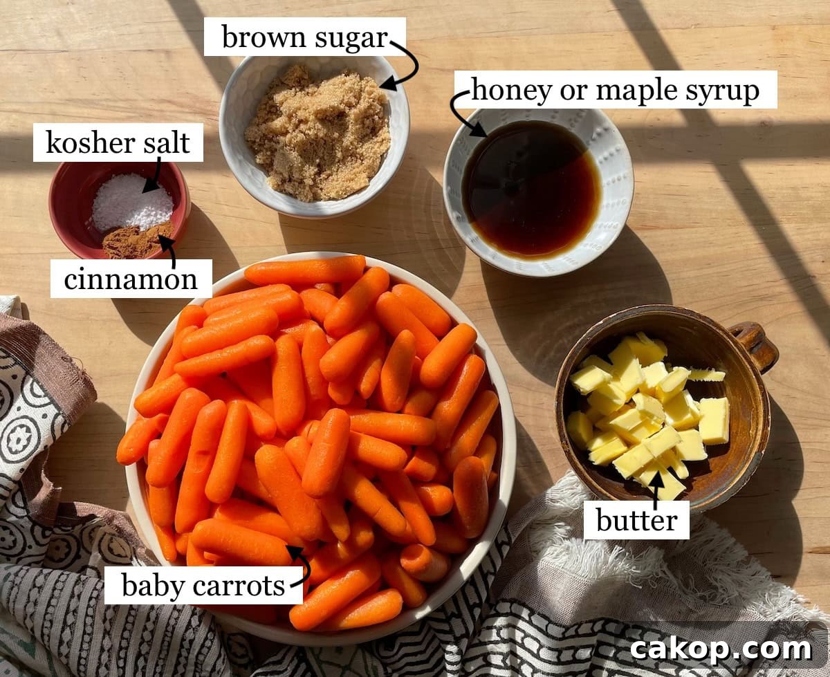 The ingredients for making glazed carrots, including baby carrots, brown sugar, honey or maple syrup, butter, cinnamon, and kosher salt on a wooden countertop with sunlight casting shadows laid out in small bowls and labeled.