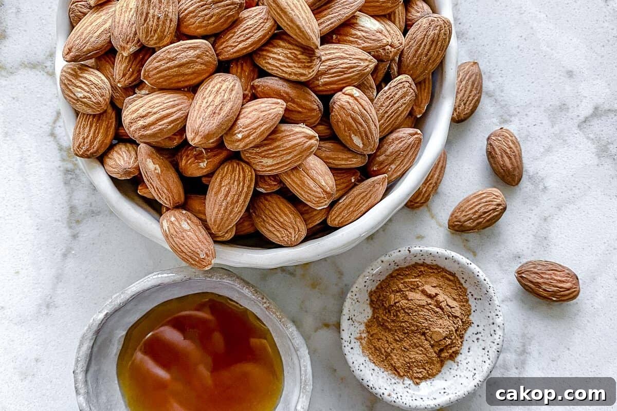 ingredients for cinnamon almonds measured out in individual bowls against white marble surface