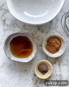 ingredients for cinnamon almonds measured out in individual bowls against white marble surface