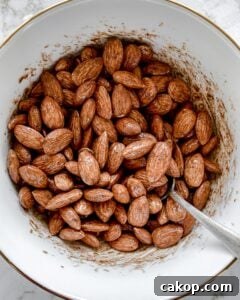 post mixing of spices for cinnamon almonds in a white bowl