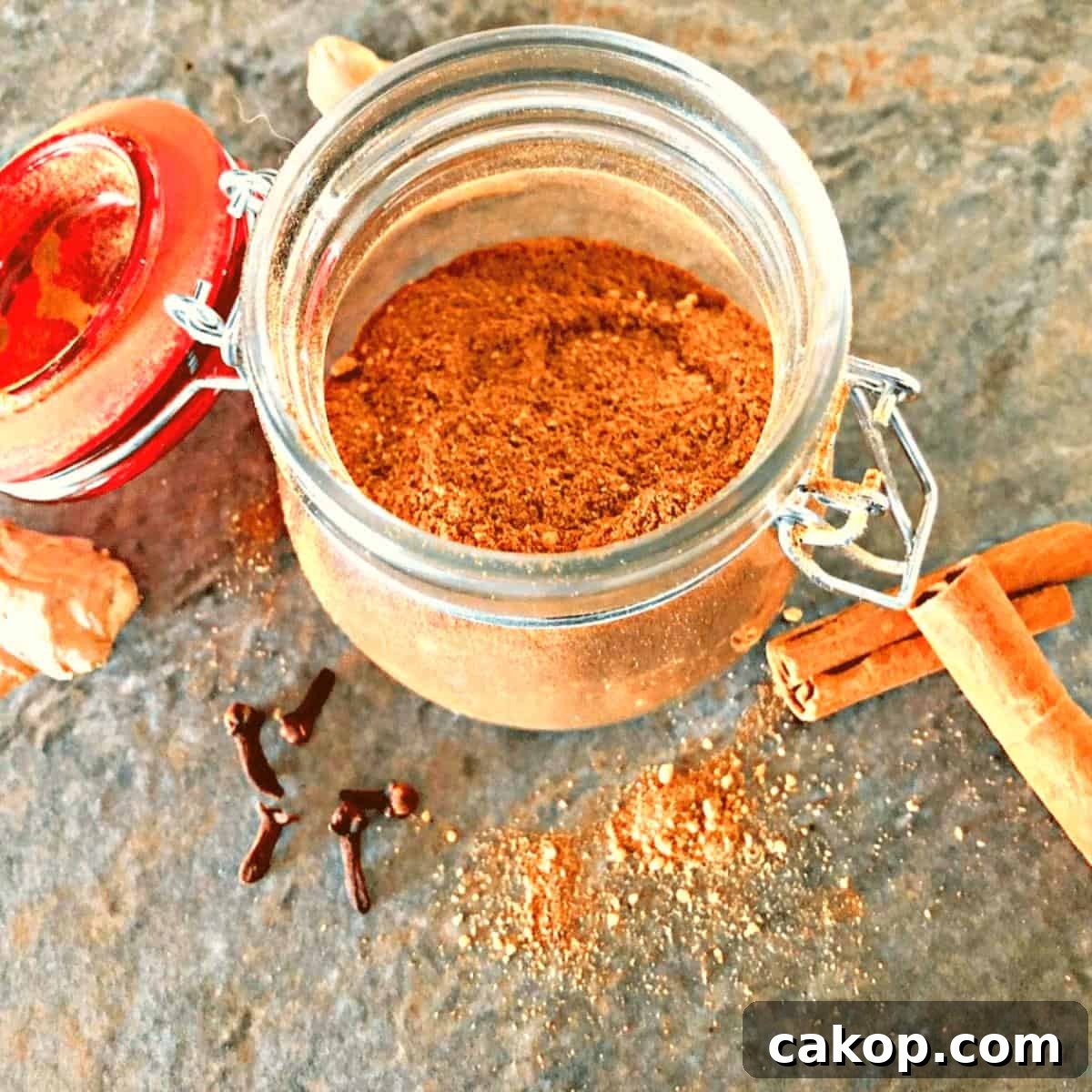 The pumpkin pie spice ingredients combined in a small glass jar.