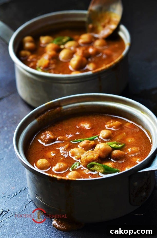 Instant Pot Chana Masala in two aluminum pots with a spoon